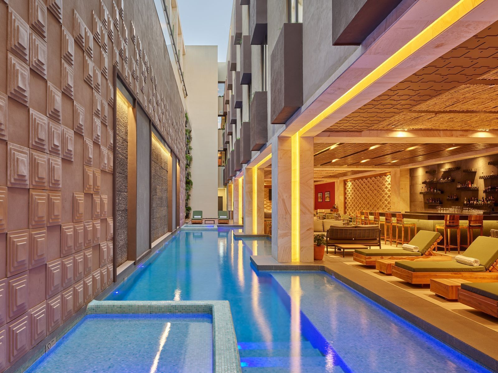 Upscale poolside lounge with bar, cushioned seating, and architectural lighting—ideal for MICE incentive travel and post-event relaxation in Oaxaca, Mexico.